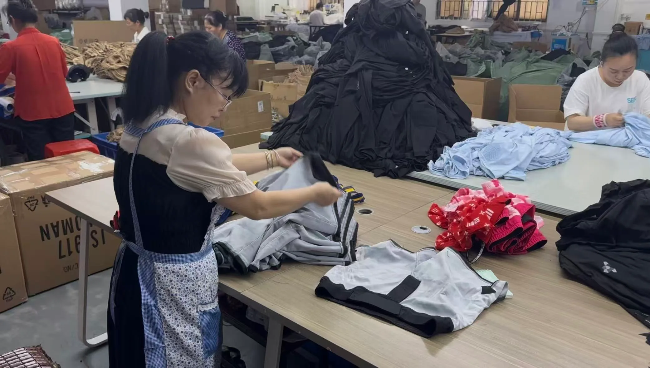 Team members handling finished sportswear during product checks