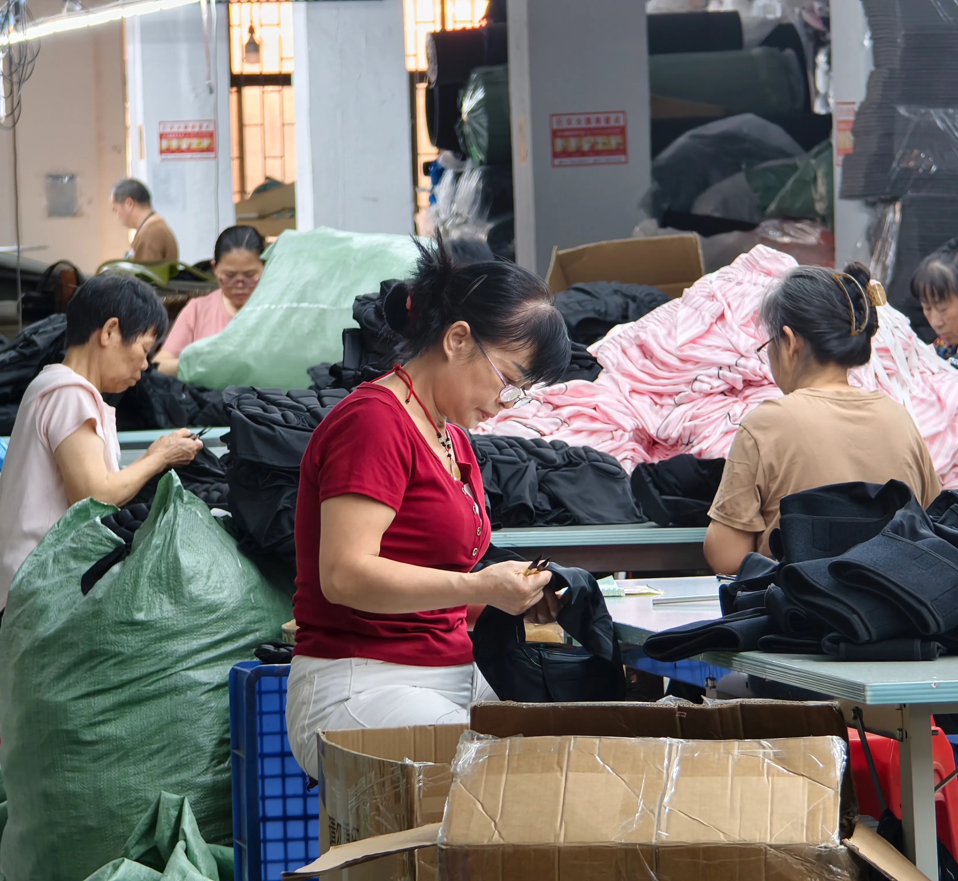 Factory worker handling a finished protective garment detail